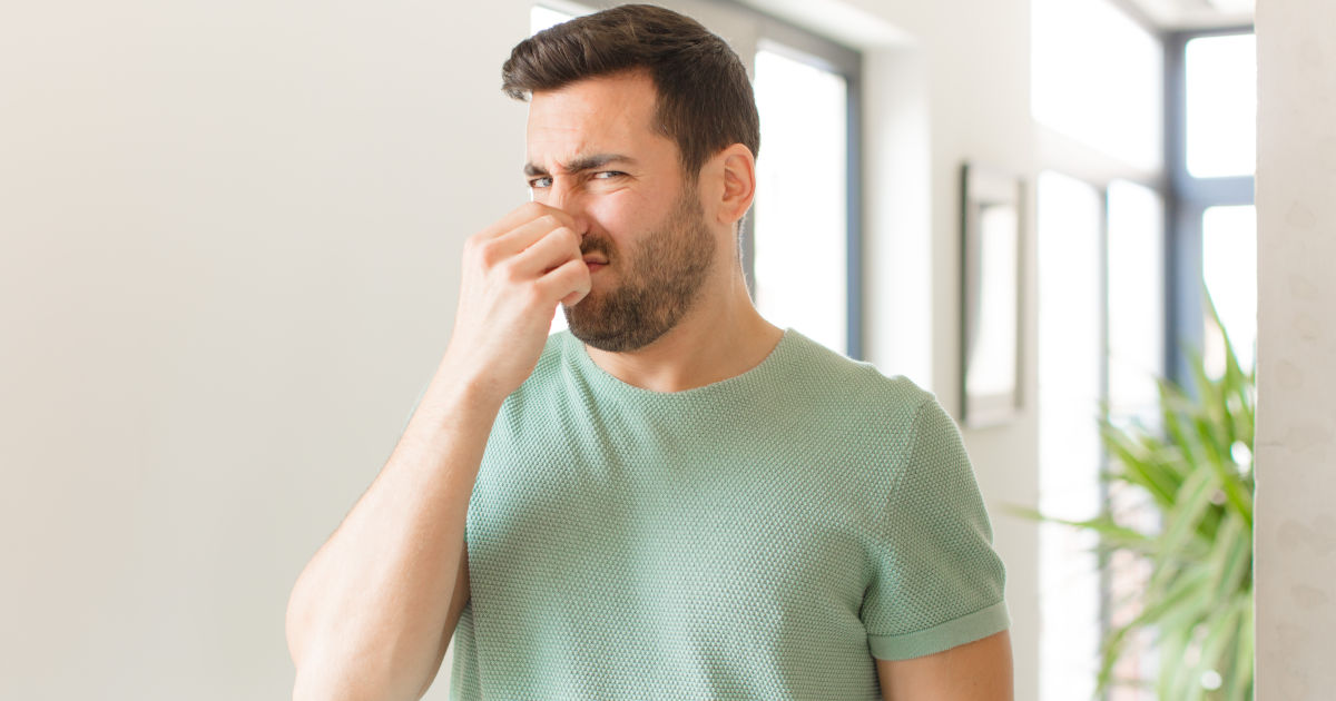 man holding nose
