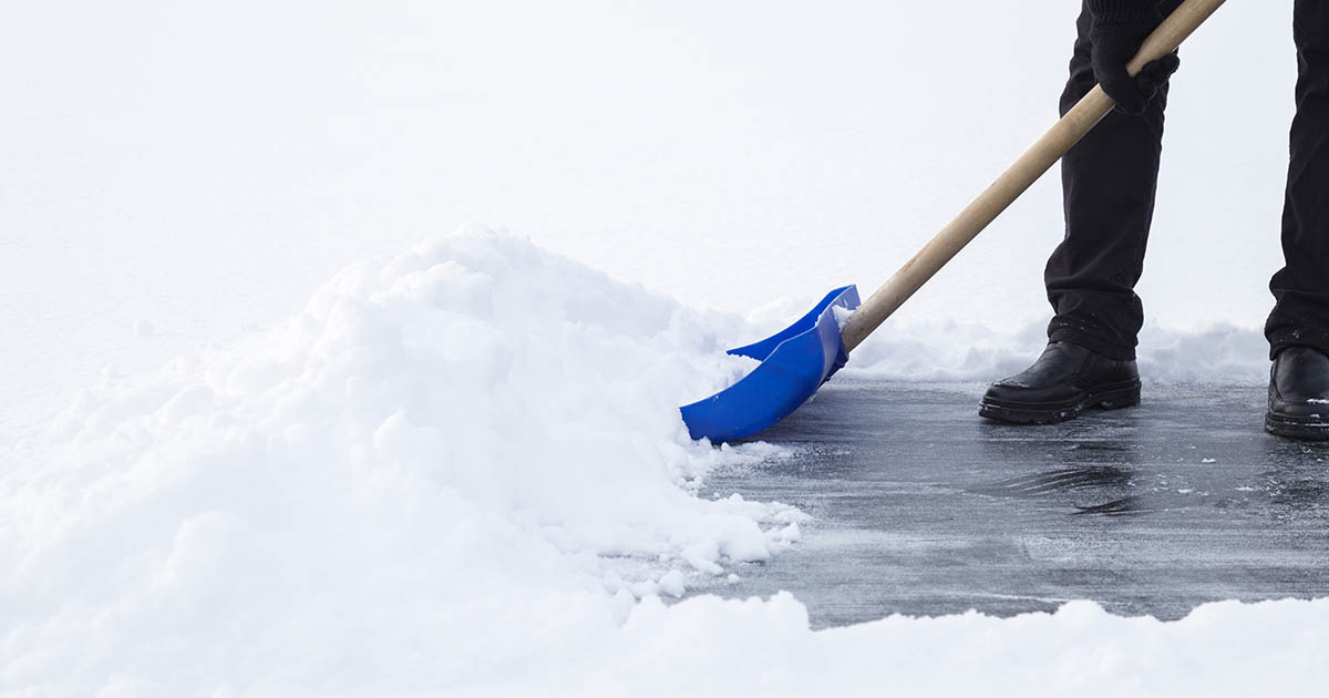Man cleaning snow with blue shovel
